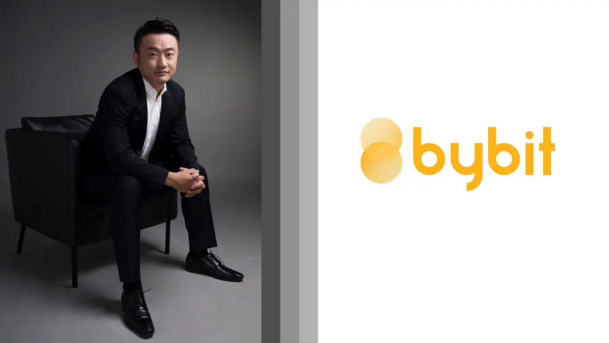 Ben Zhou sitting on a black chair in a suit, with a Bybit logo to the right.