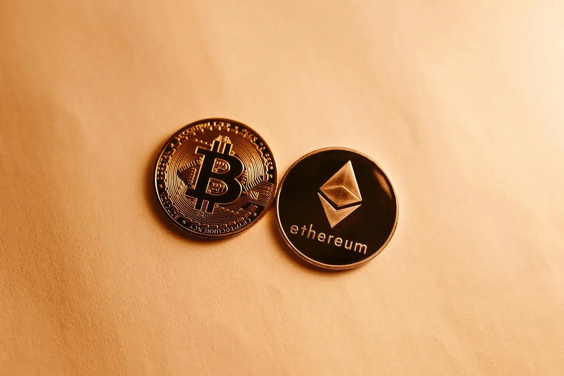 Bitcoin and Ethereum coins resting on a light background.