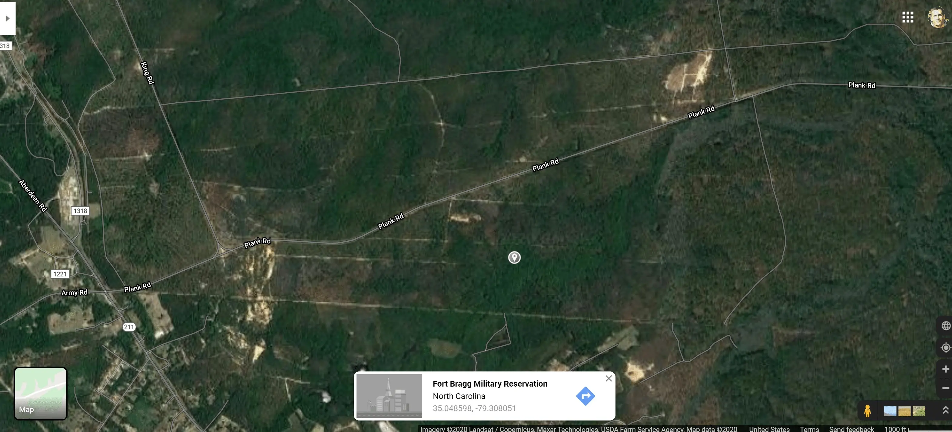 Aerial view of Fort Bragg Military Reservation in North Carolina with visible roads and forested areas.