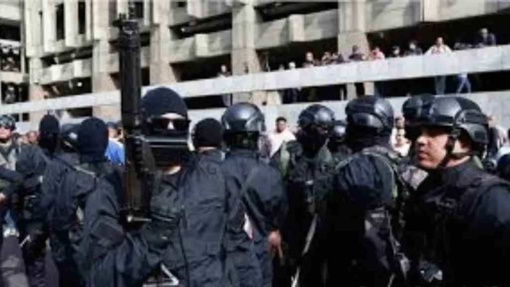 Armed tactical team in black uniforms during a military operation in an urban area.