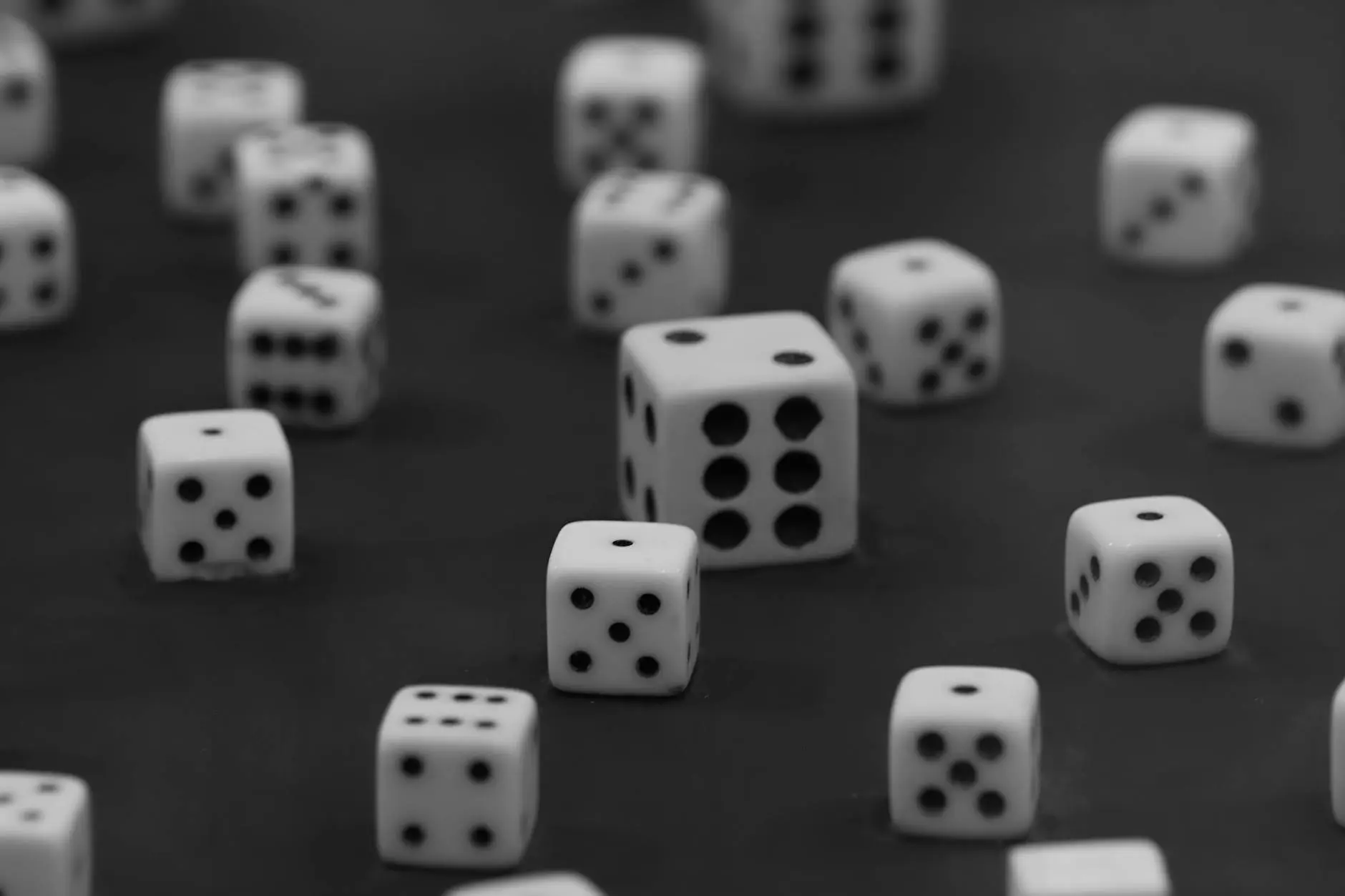 A scattered arrangement of white dice showing various numbers in black dots on a dark background.
