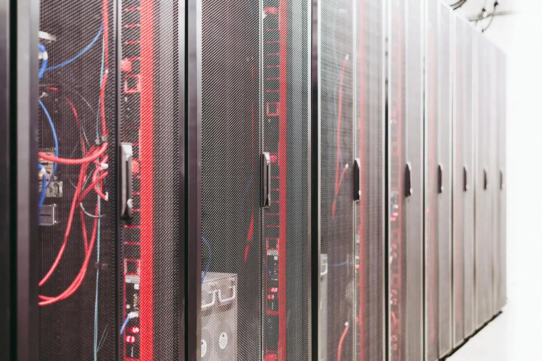 Rows of server racks in a data center with visible cables and hardware components.