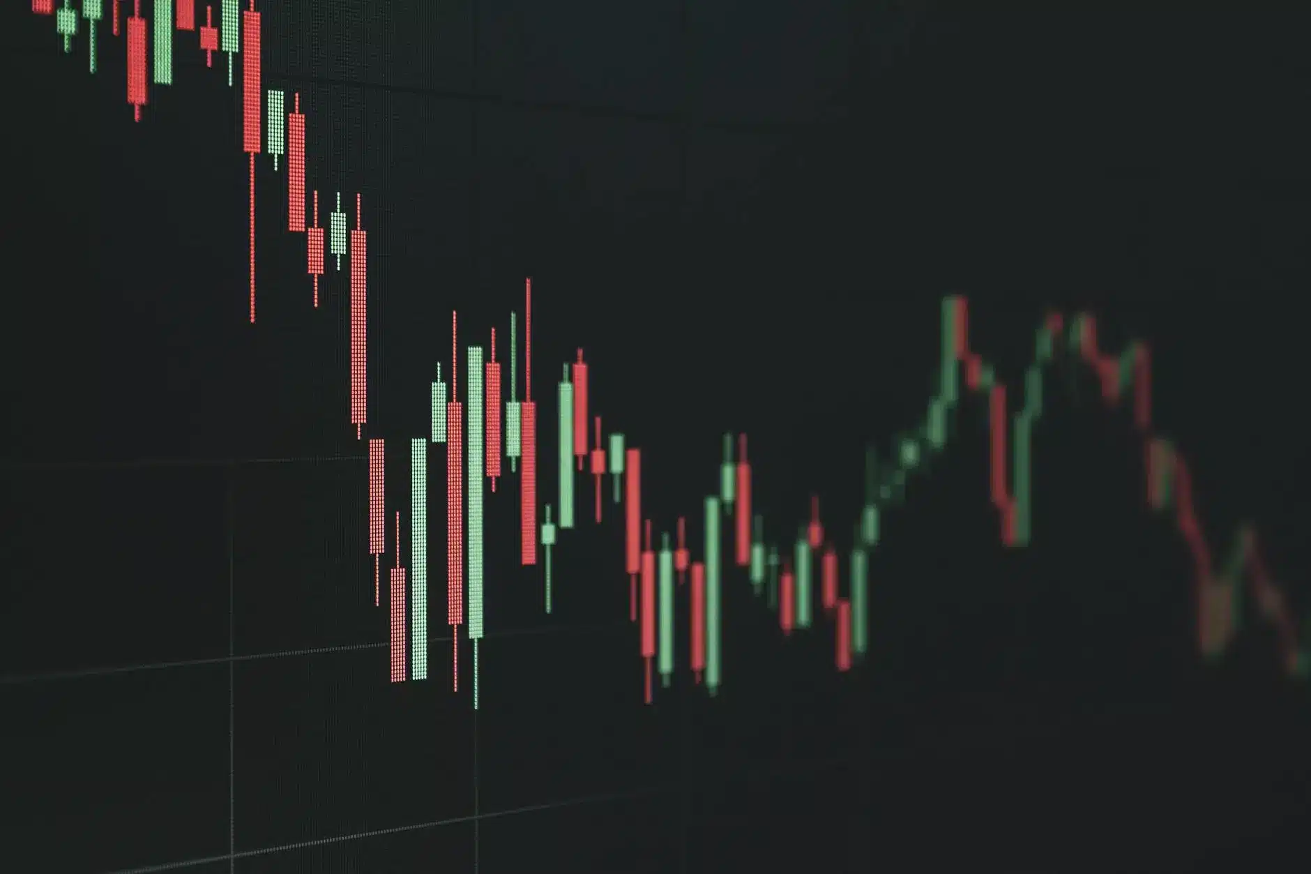 Close-up of stock market candlestick chart showing decline with red and green bars.
