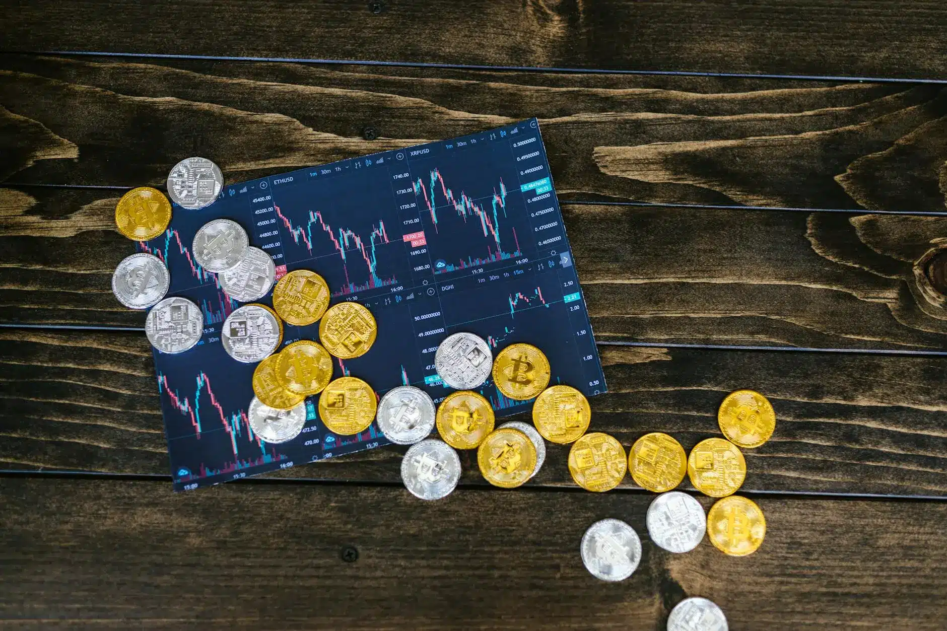 A selection of cryptocurrency coins scattered on a trading chart displaying price movements.