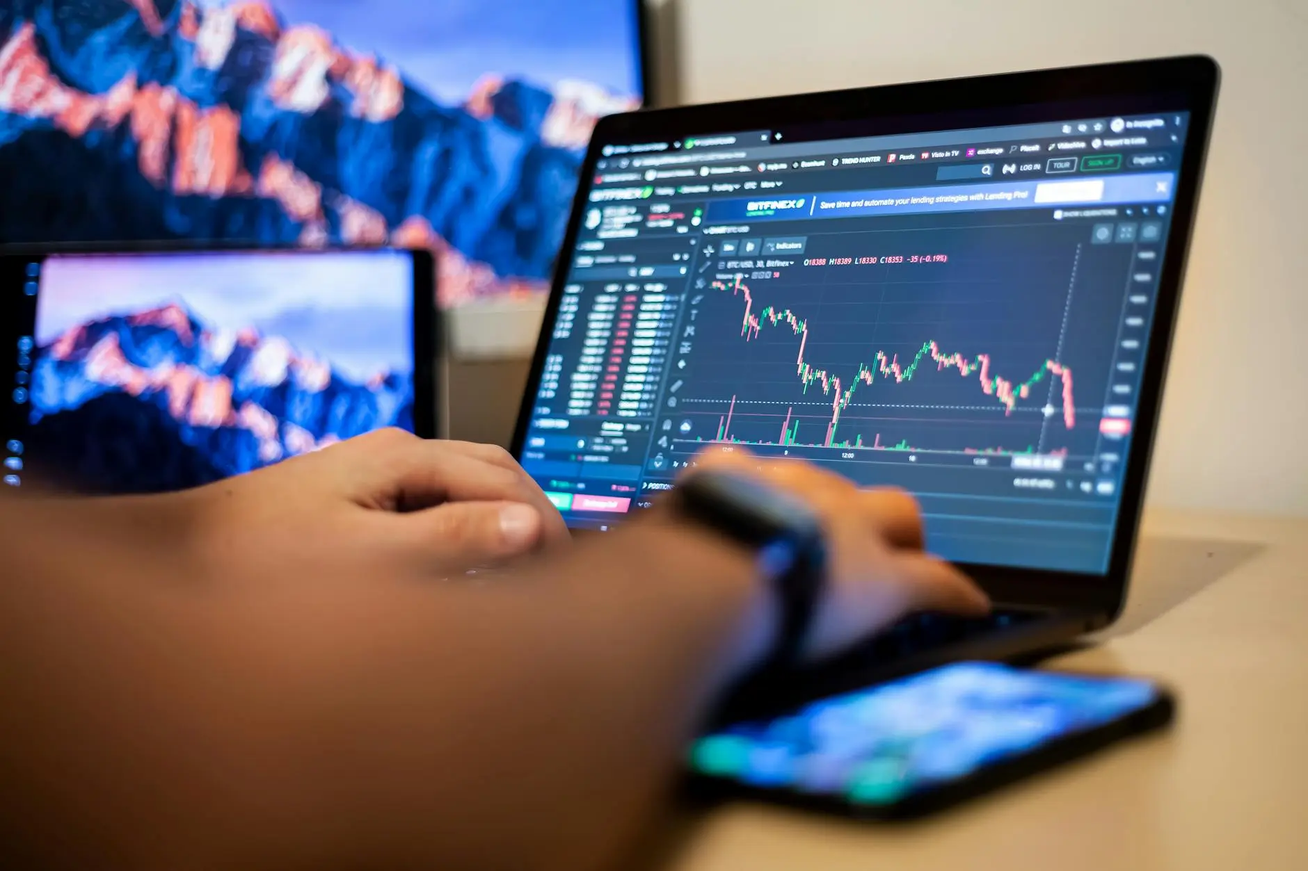 Close-up of a person trading cryptocurrency on a laptop with price charts.