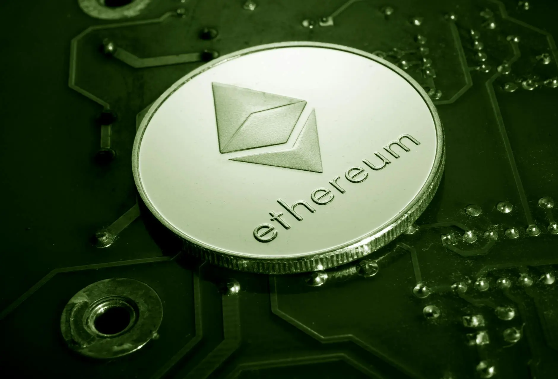 Silver Ethereum coin positioned on a green circuit board background.