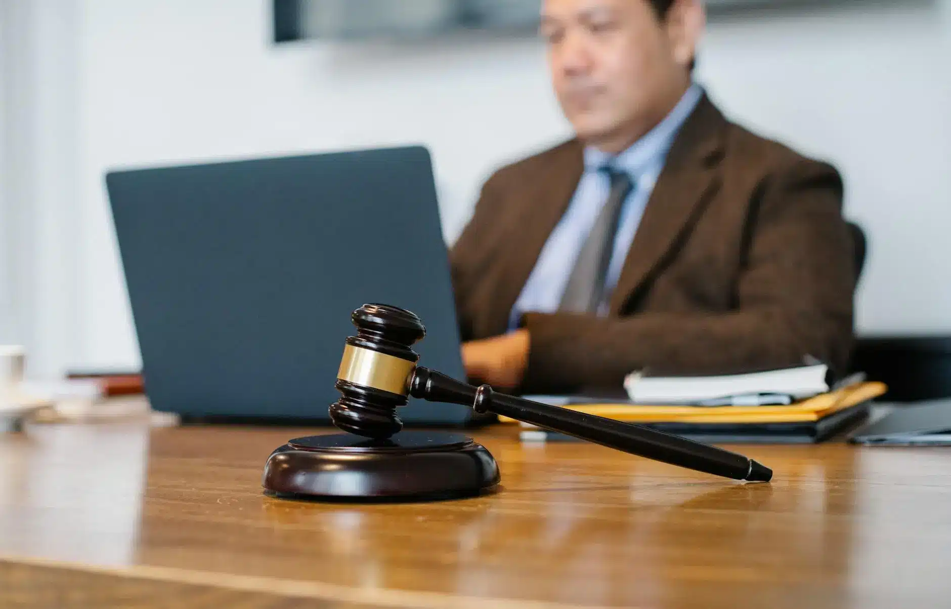 Gavel rests on a table near a laptop and office supplies.