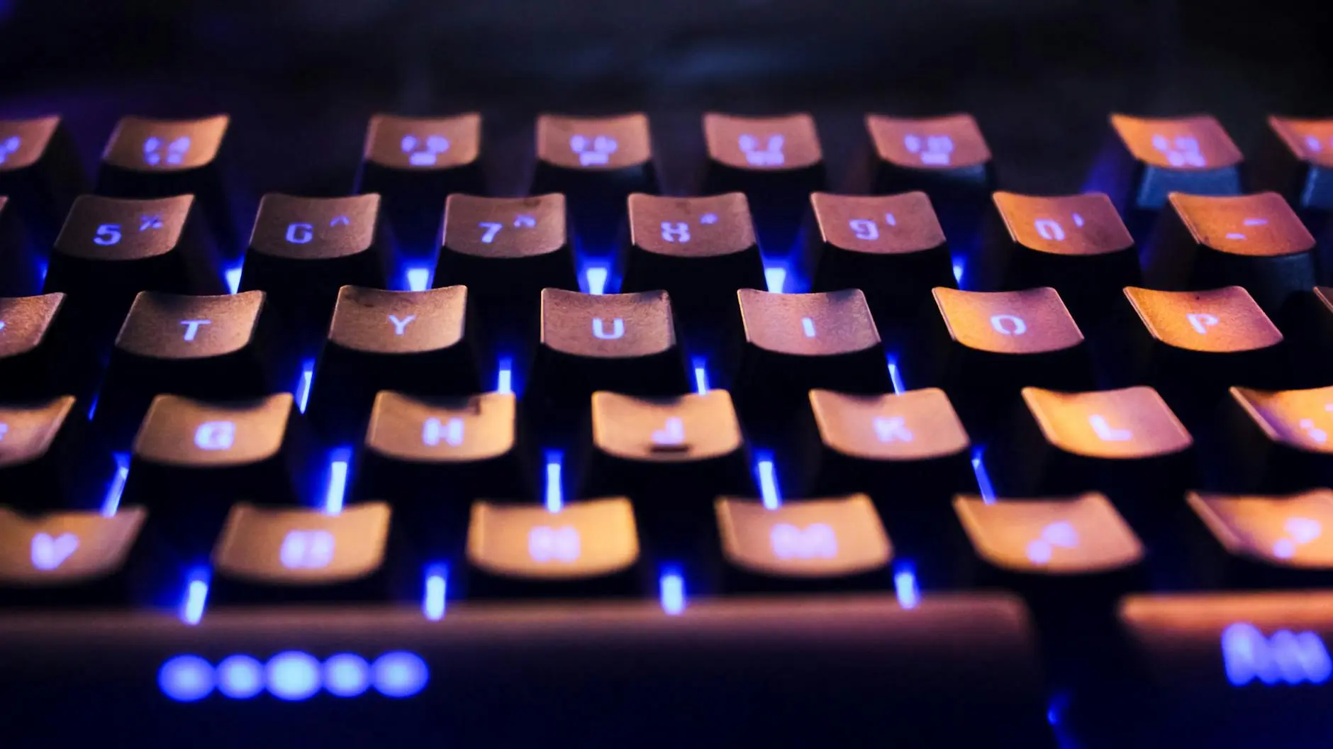 Close-up of a laptop keyboard with blue backlighting highlighting the keys.