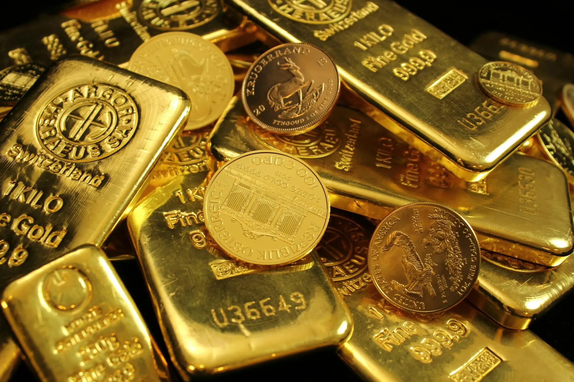 Gold bars and coins stacked together in a vault-like arrangement.