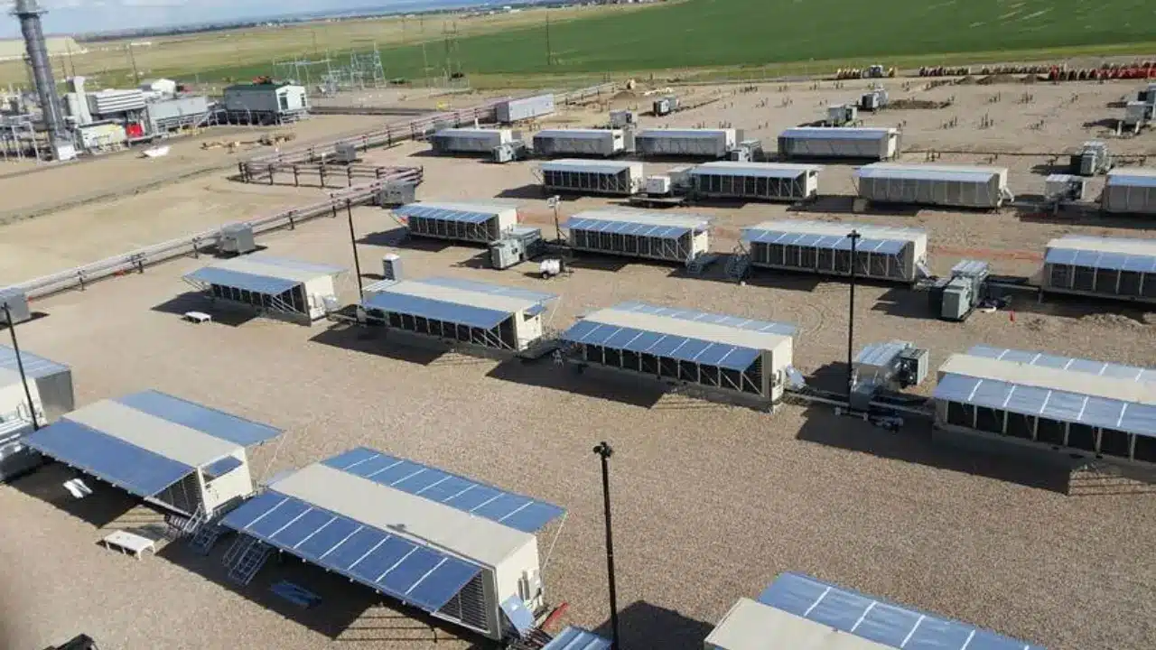 Aerial view of Hut 8 Bitcoin mining facility with numerous modular units and solar panels.