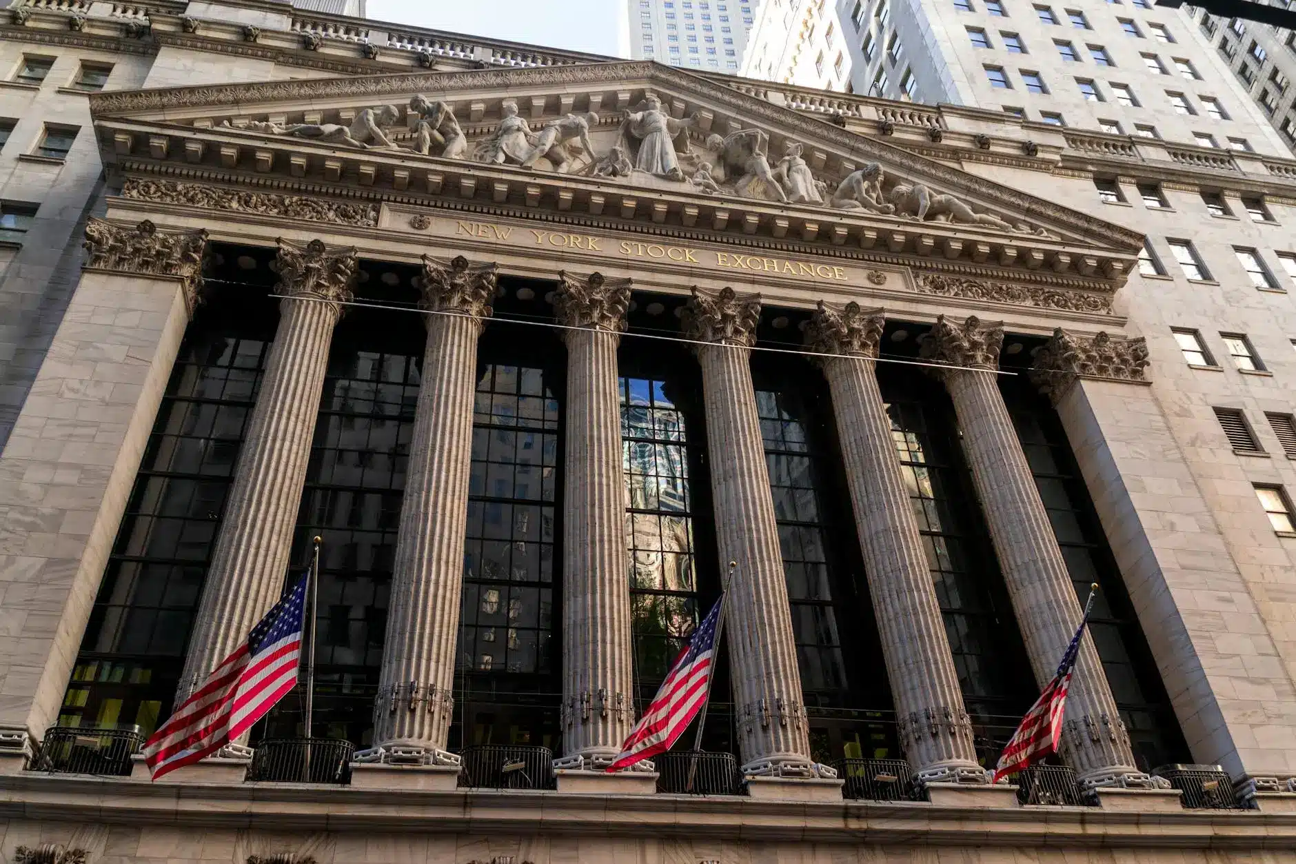 The New York Stock Exchange building with American flags and classical architecture.