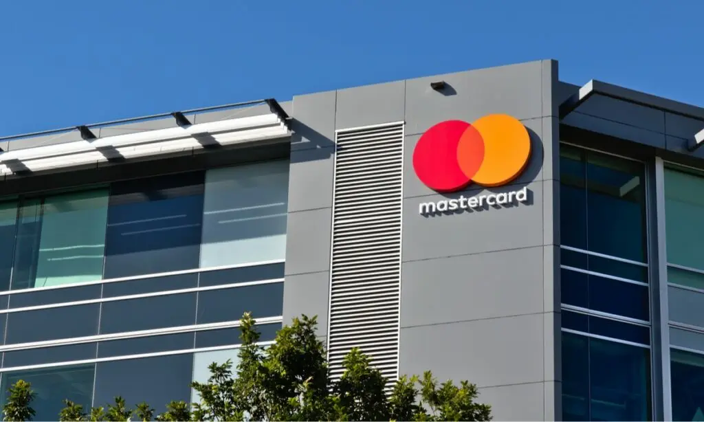 Mastercard logo on the exterior of an office building against a blue sky.
