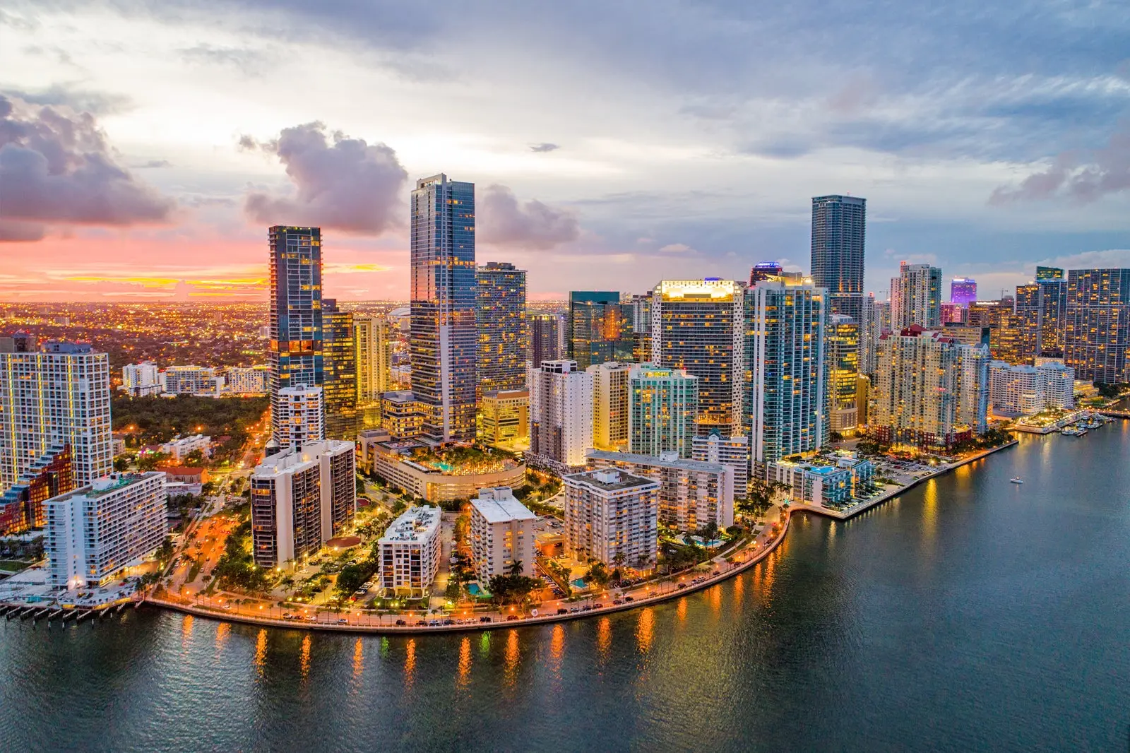 Miami skyline at sunset with Brickell financial district buildings and water view.