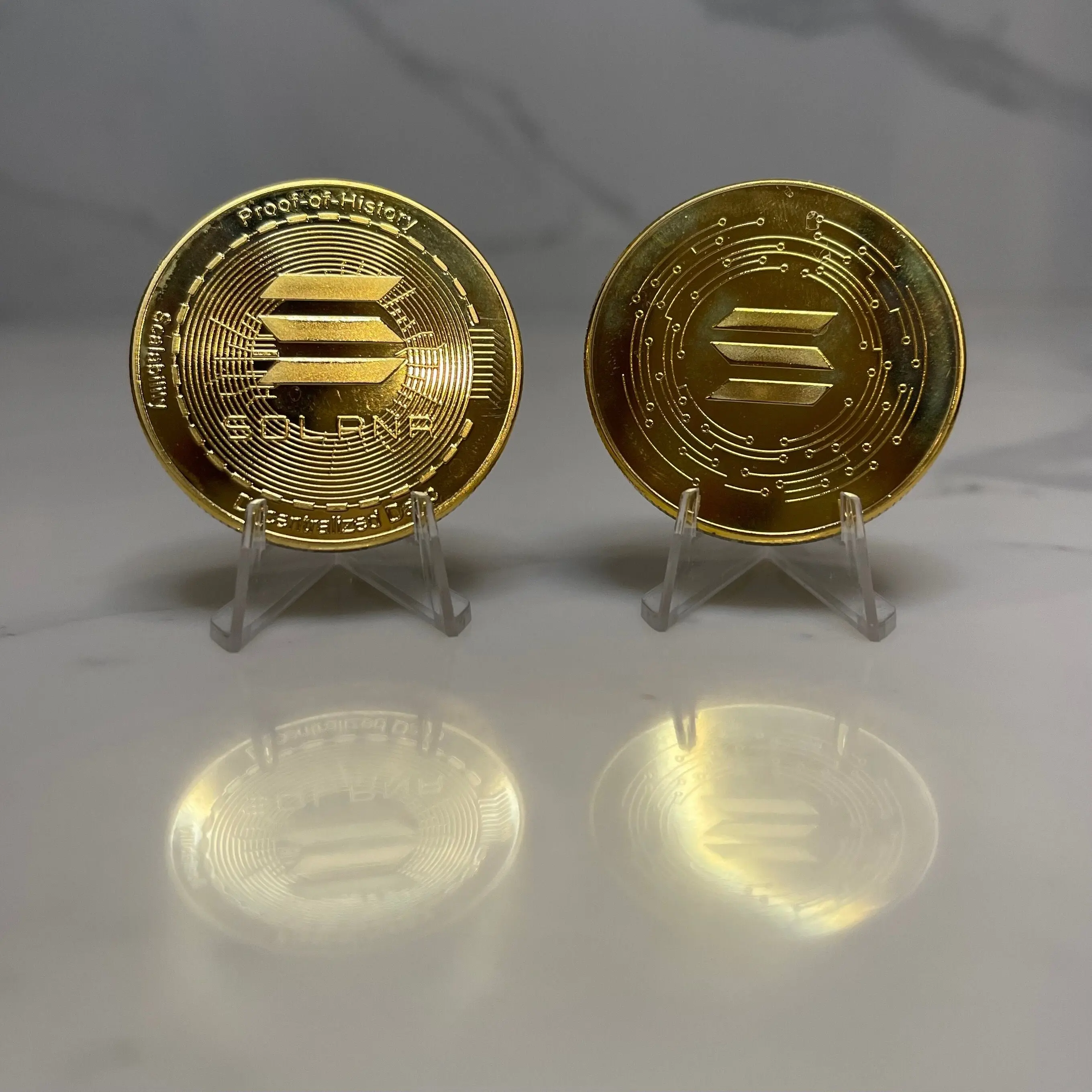 Two physical tokens representing Solana's SOL coin on display.