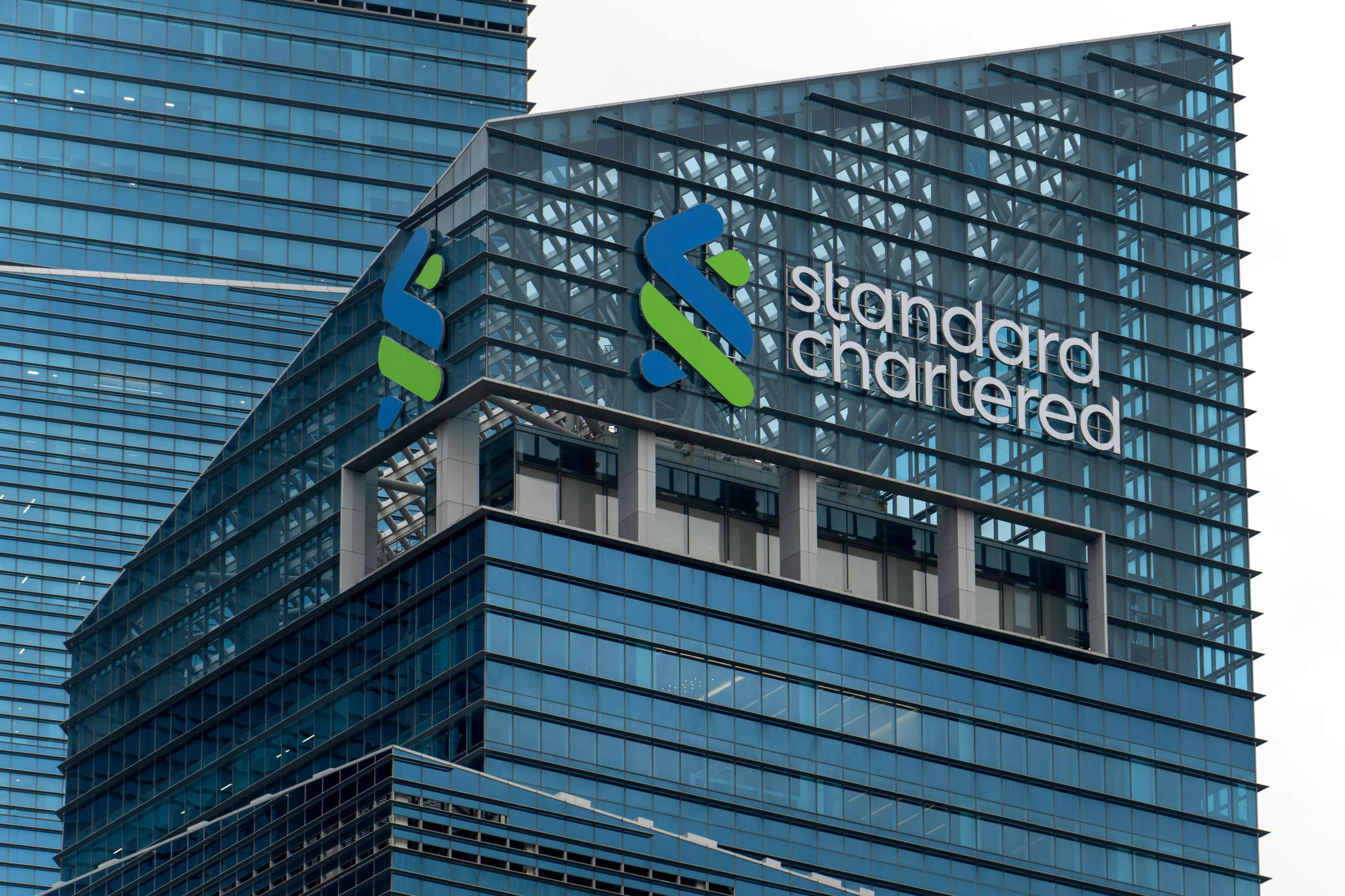 Standard Chartered tower in Singapore displaying the company logo.