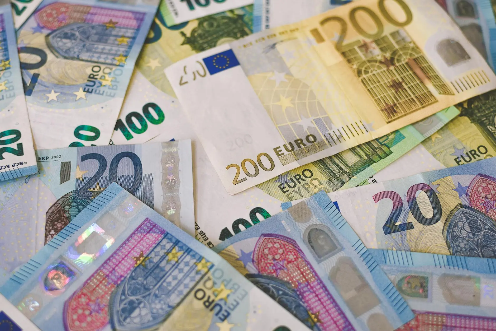 Various denominations of Euro banknotes including 20, 100, and 200 Euro bills spread out.