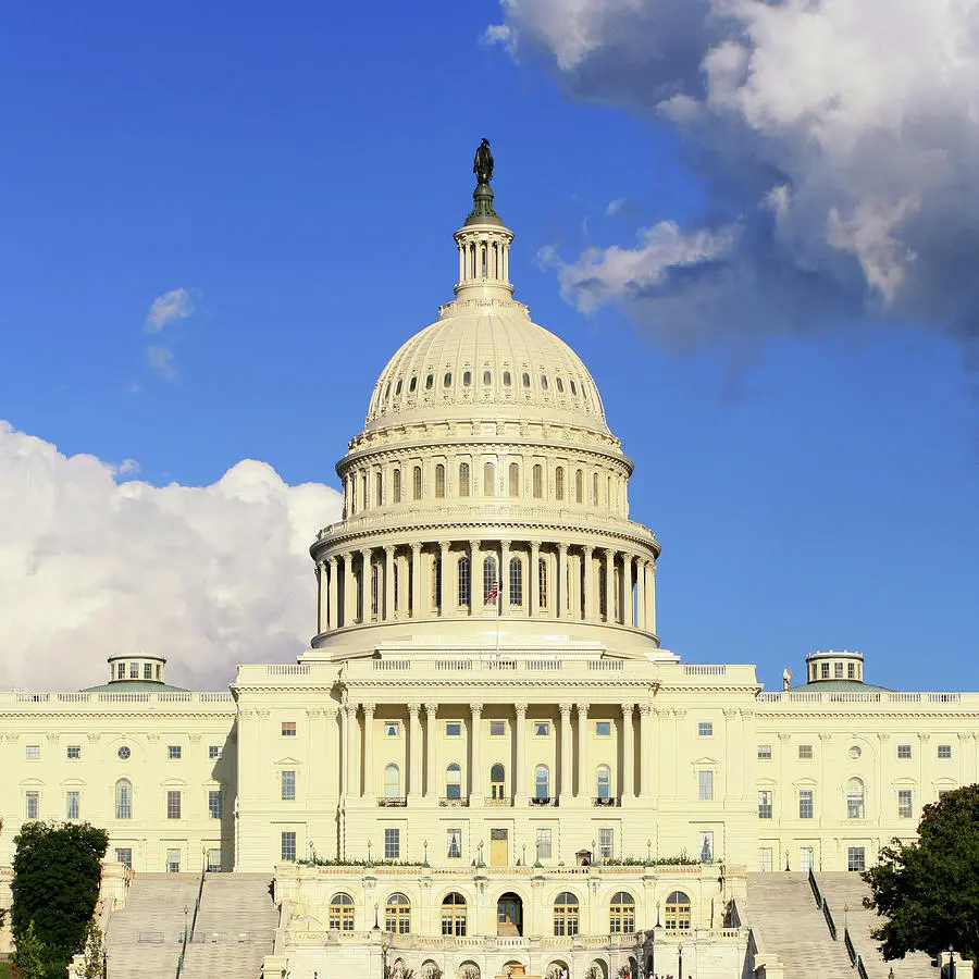 The US Capitol building in Washington DC against a blue sky.