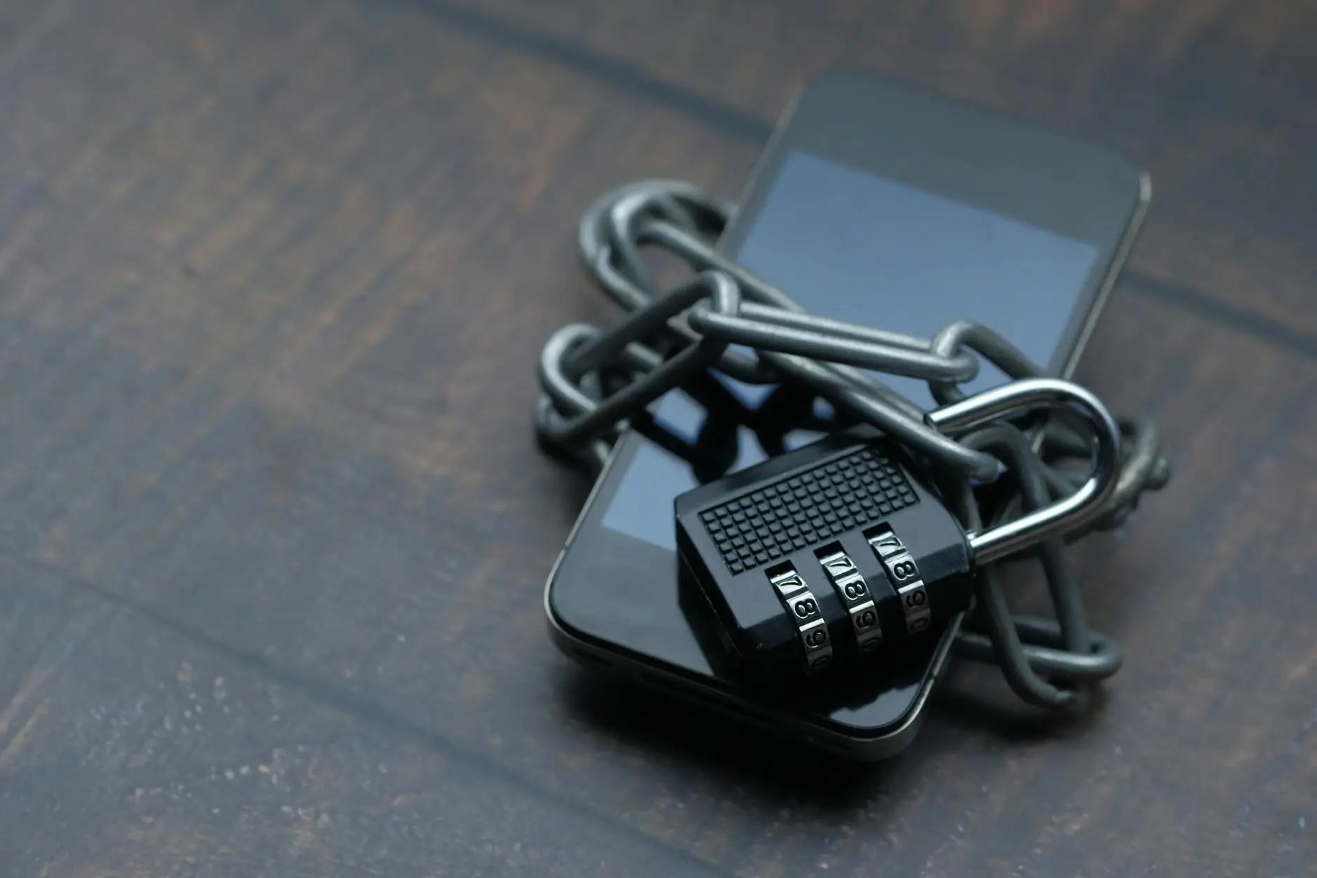 A phone secured with a chain and combination lock, symbolizing cybersecurity.