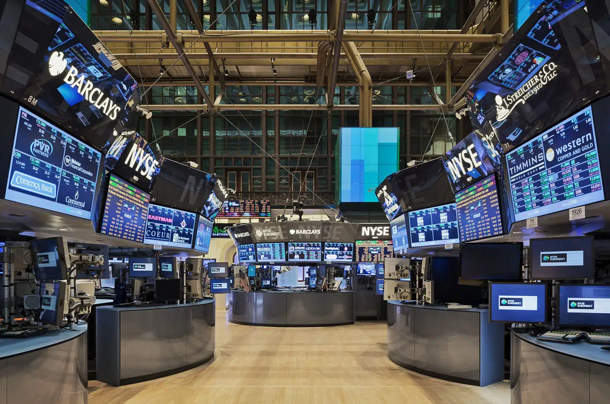 Interior view of the New York Stock Exchange trading floor with digital screens.