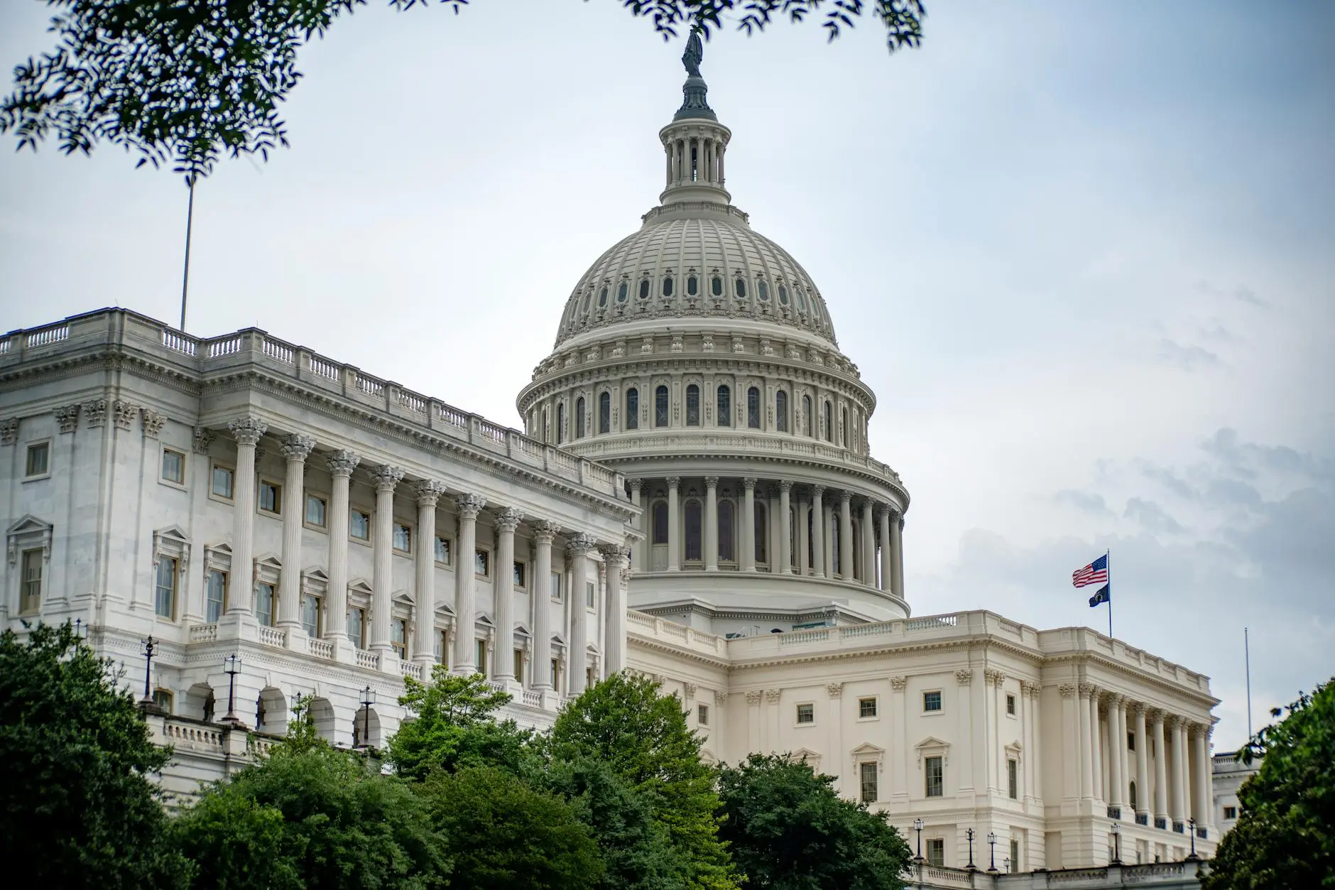 US Capitol building with a prominent dome and American flag visible.