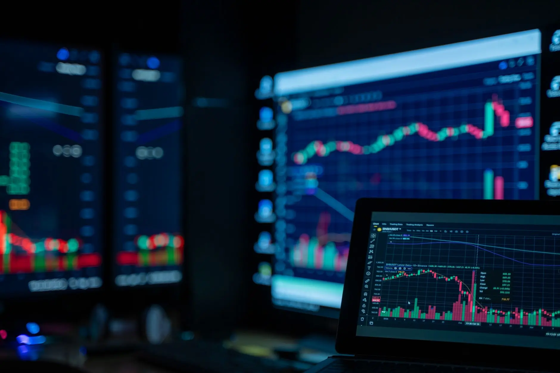 Multiple computer screens displaying financial trading charts and data.