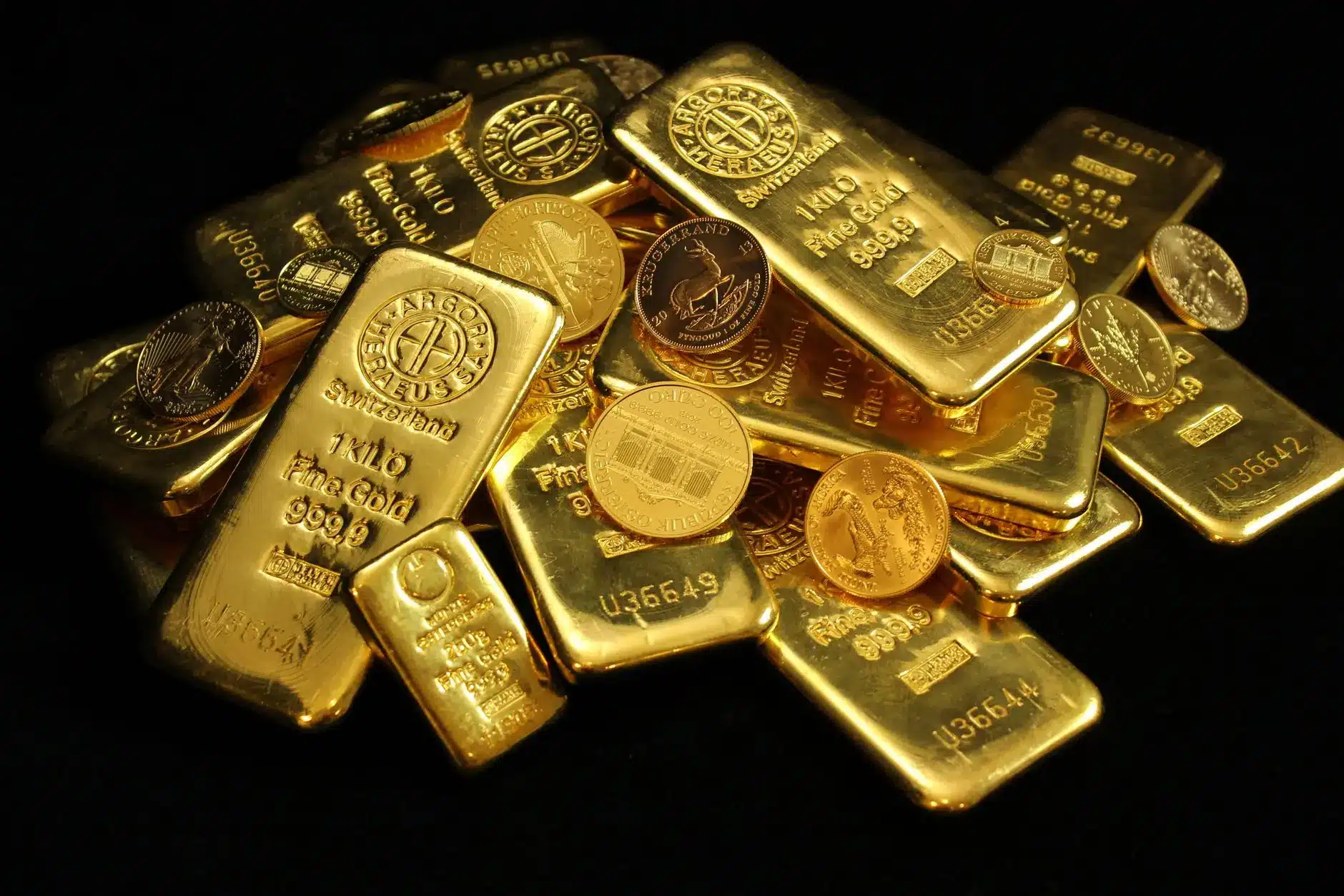 A pile of gold bars and coins showcasing fine gold bullion investment.